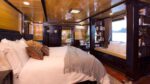 Hera Cruise Suite with a Small Bench next to a Large Glass Window for Sightseeing