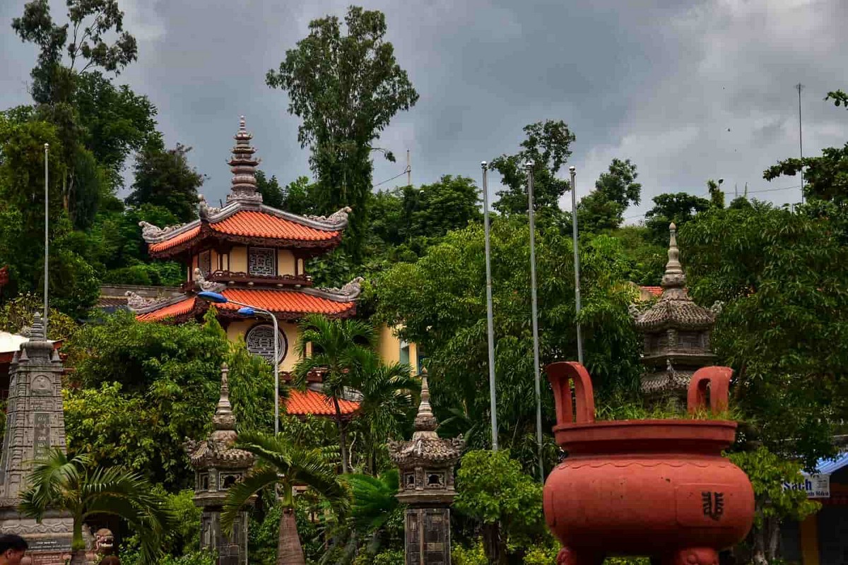 The peaceful atmosphere with tall, ancient trees surrounding Long Son Temple Nha Trang