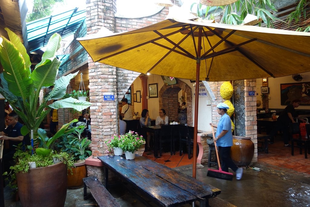 Best Restaurants in Vung Tau Banh Khot Co Ba offers a cozy atmosphere with numerous trees and wooden tables and chairs